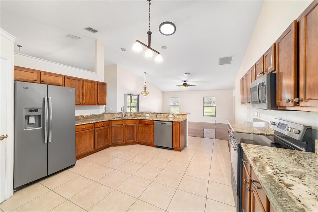 4037 Southeast 40th Street Ocala, FL 34480 - Photo 20 of 38 a large kitchen with stainless steel appliances cabinets a sink and a stove