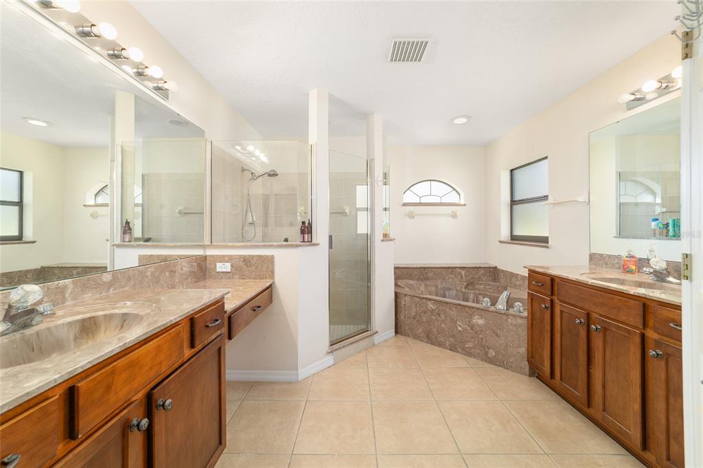 4037 Southeast 40th Street Ocala, FL 34480 - Photo 25 of 38 a large bathroom with a granite countertop double vanity sink a mirror and a