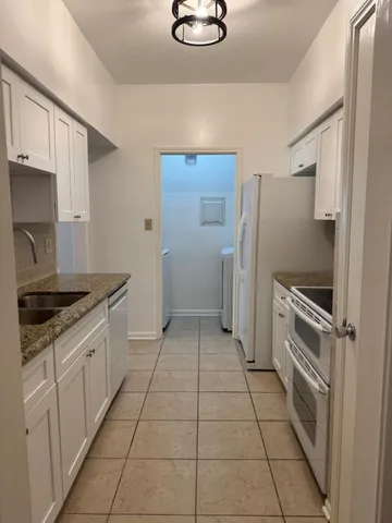 a kitchen with granite countertop a refrigerator and a stove
