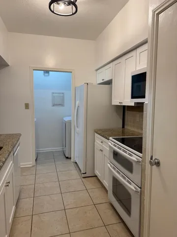 a kitchen with a refrigerator a stove and a sink