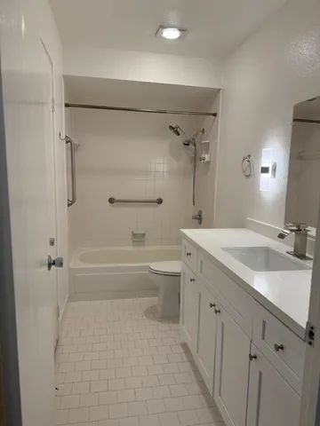 a bathroom with a granite countertop sink a toilet and shower