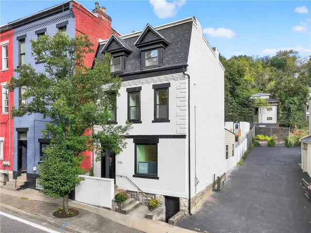 a front view of a house with plants