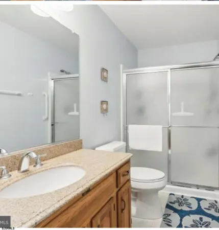 a bathroom with a granite countertop sink toilet and shower