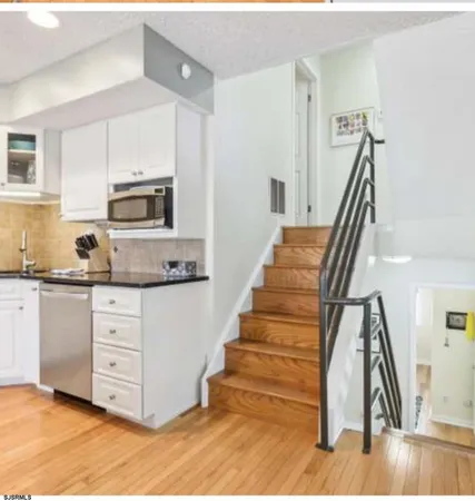 a kitchen with wooden floors and white appliances