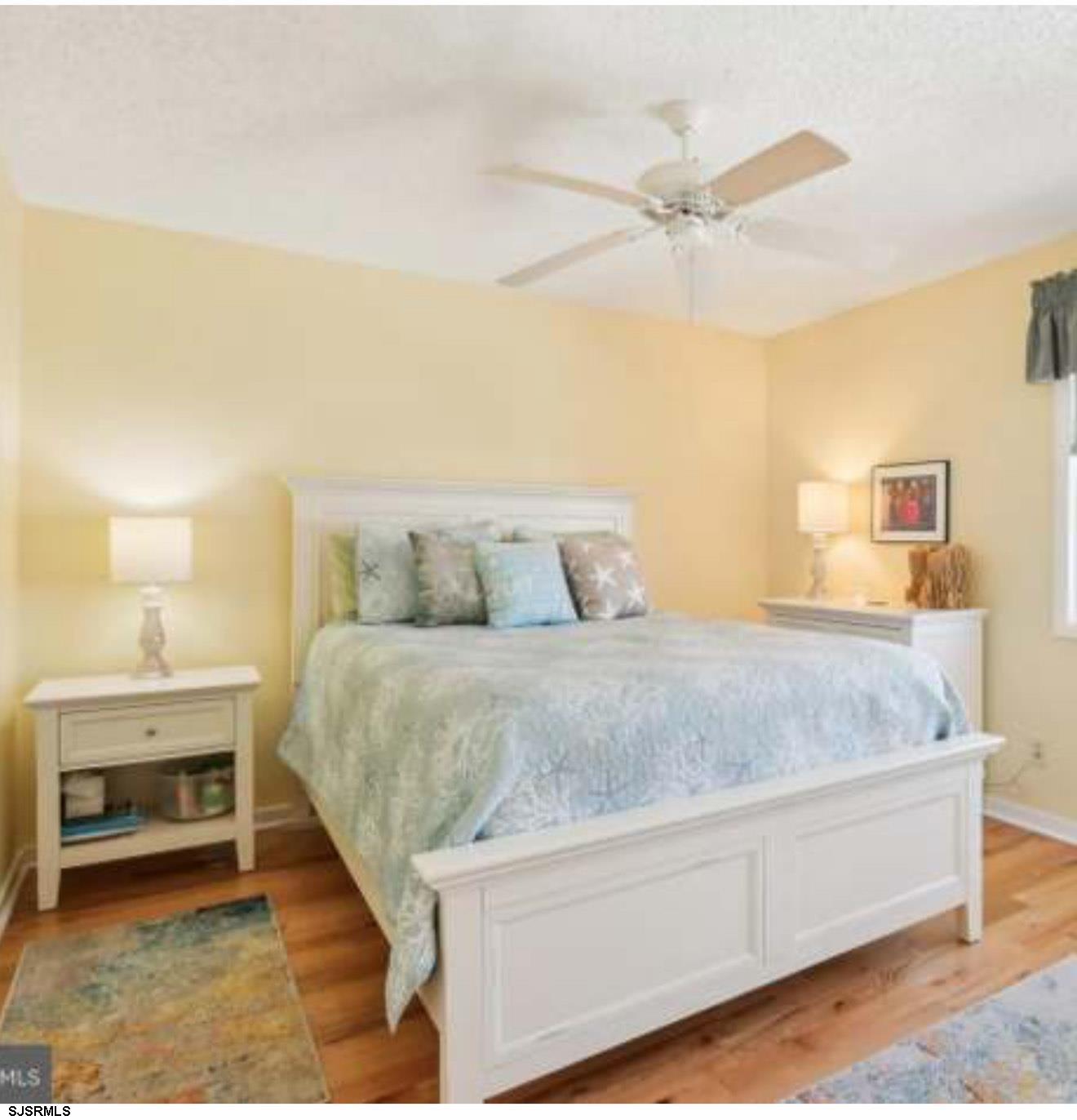 205 4th Street North, Unit 205B Brigantine, NJ 08203 - Photo 9 of 19 a bedroom with a bed and a chandelier