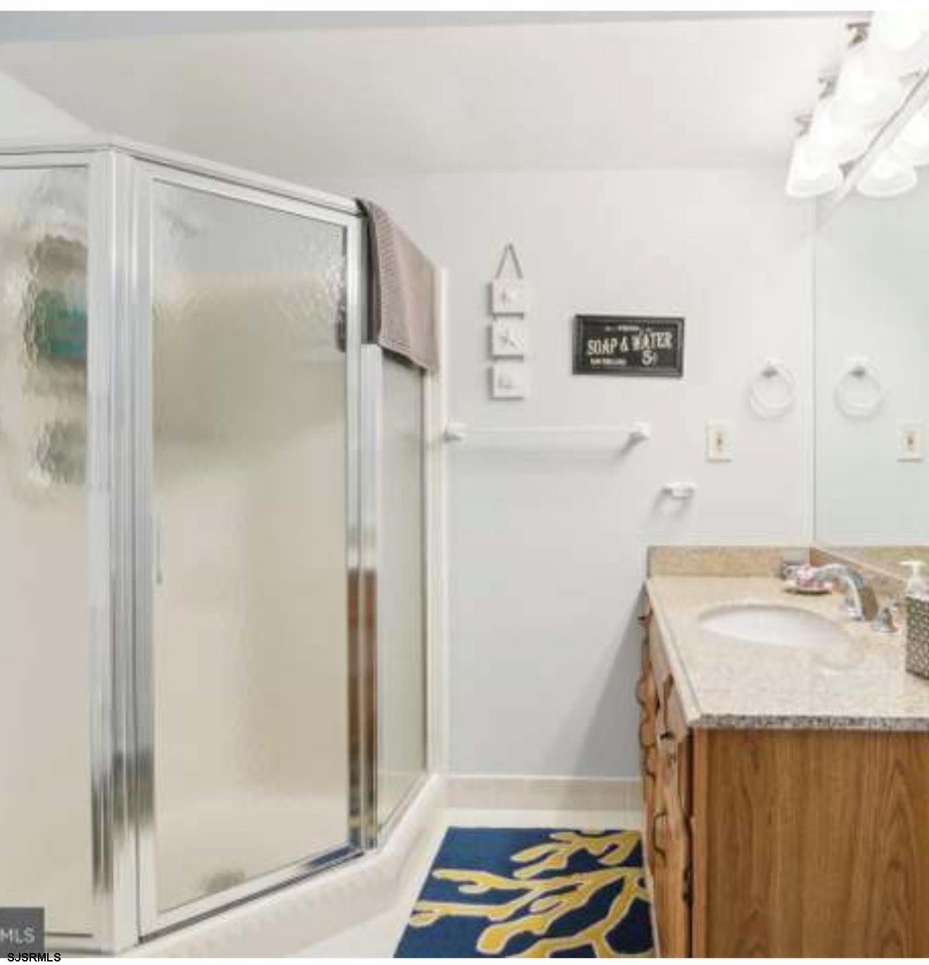 205 4th Street North, Unit 205B Brigantine, NJ 08203 - Photo 10 of 19 a bathroom with a sink and a mirror