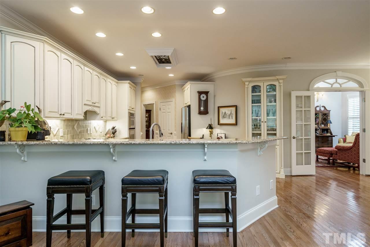 1901 Torrington Street Raleigh, NC 27615 - Photo 11 of 30 a kitchen with a table chairs refrigerator and cabinets