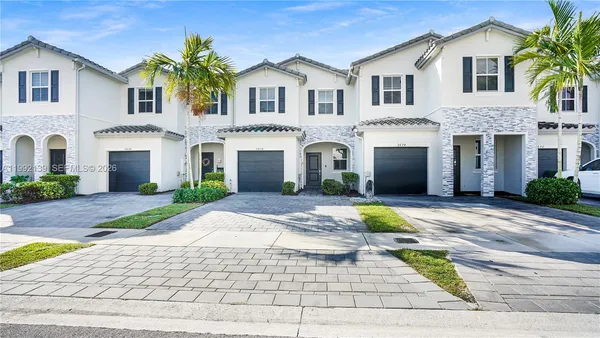 a front view of a house with a garden and plants