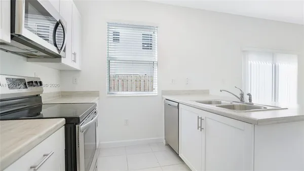 a kitchen with a sink cabinets and window