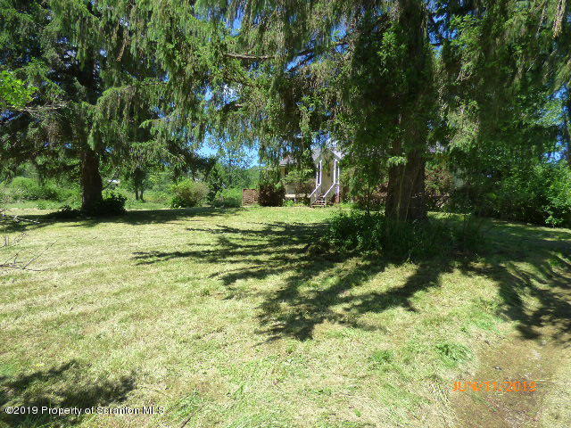 1957 Mack Road Kingsley, PA 18826 - Photo 30 of 31 a backyard of a house with a yard and large trees