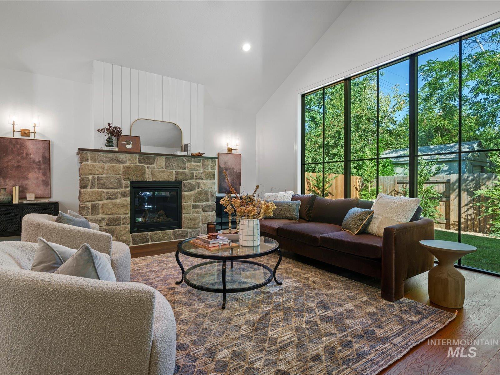 2834 West Cassia Street Boise, ID 83705 - Photo 3 of 15 Living area featuring wood finished floors, a stone fireplace, recessed lighting, and high vaulted ceiling