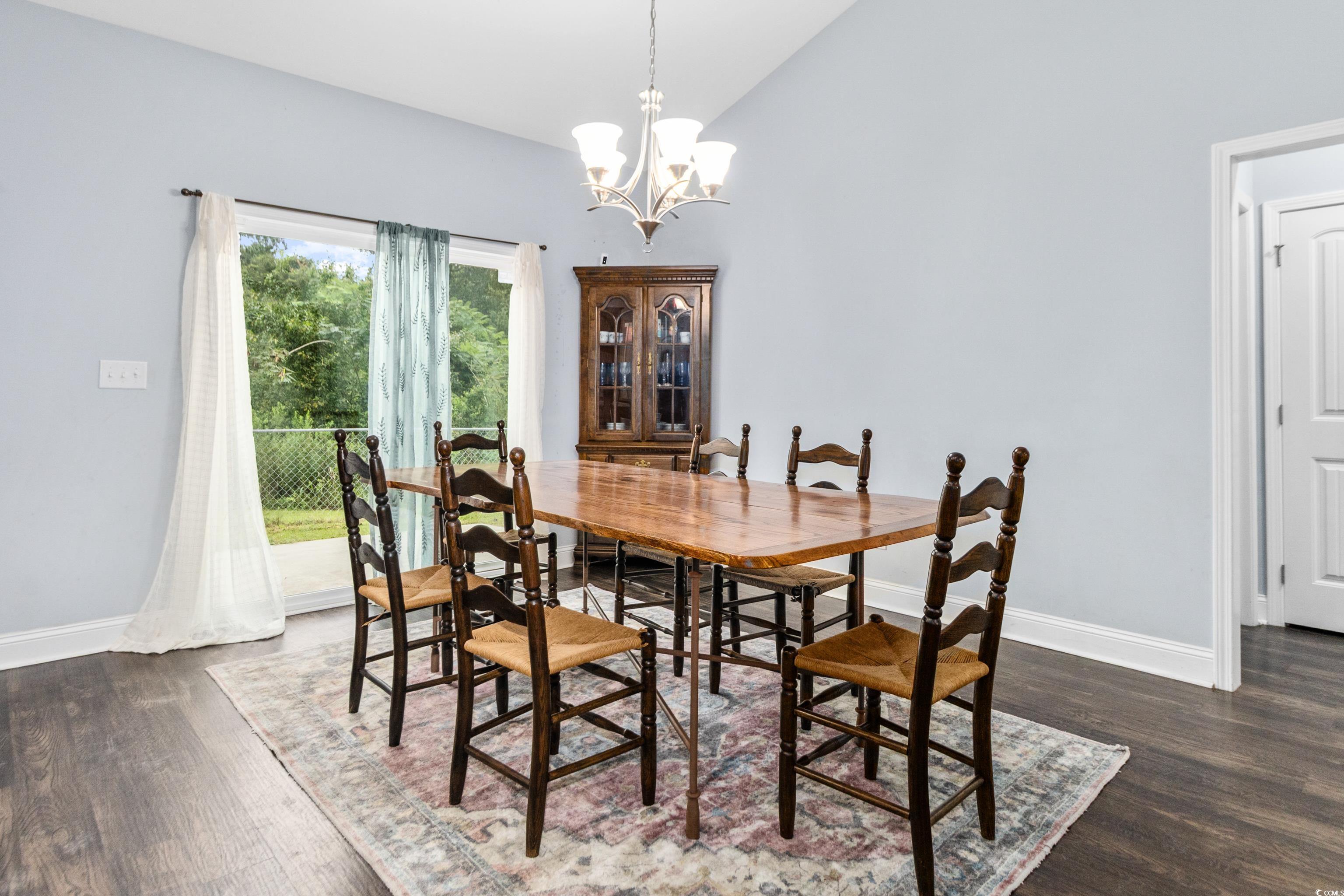 4867 Wolf Trail Conway, SC 29527 - Photo 12 of 31 Dining area featuring a chandelier, dark wood-type flooring, and high vaulted ceiling