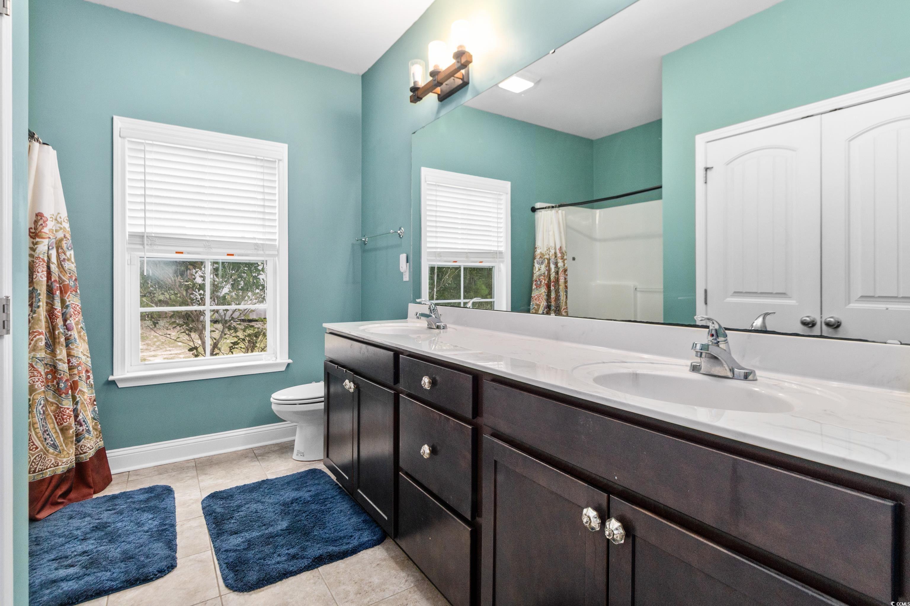 4867 Wolf Trail Conway, SC 29527 - Photo 17 of 31 Full bath featuring light tile patterned floors, double vanity, and curtained shower