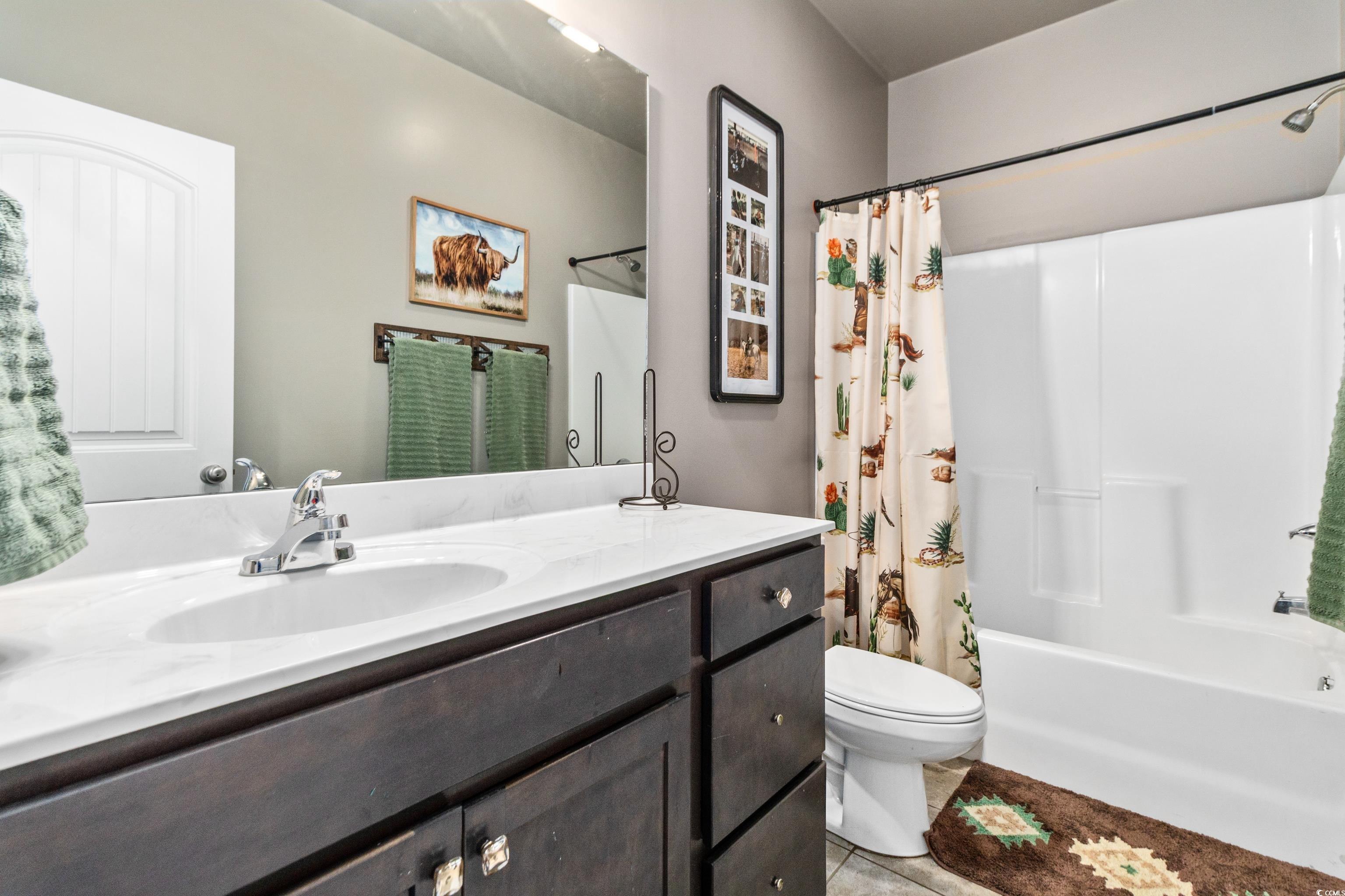 4867 Wolf Trail Conway, SC 29527 - Photo 19 of 31 Bathroom with shower / bath combo with shower curtain, light tile patterned flooring, and vanity