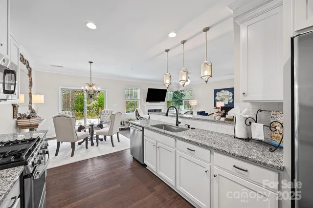 a large kitchen with lots of counter space a sink appliances and living room view