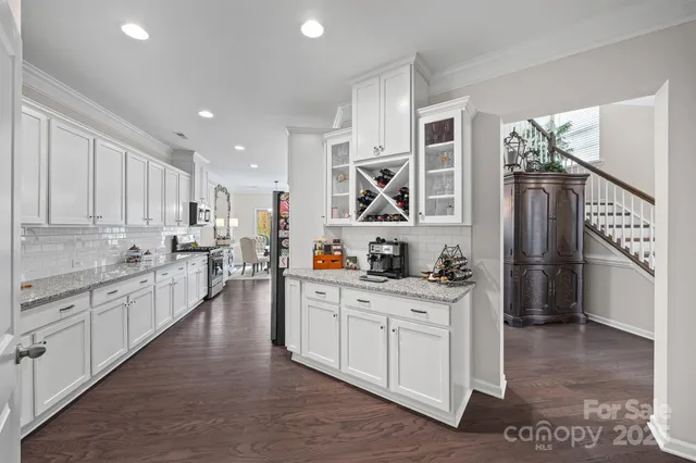 a kitchen with stainless steel appliances kitchen island granite countertop a stove a sink a refrigerator and cabinets