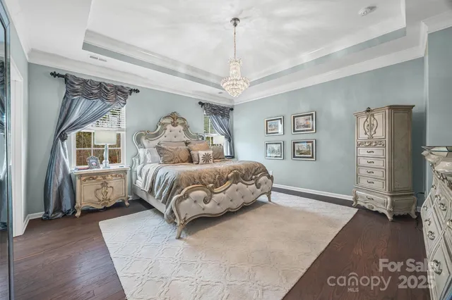 a bedroom with a large bed and a chandelier