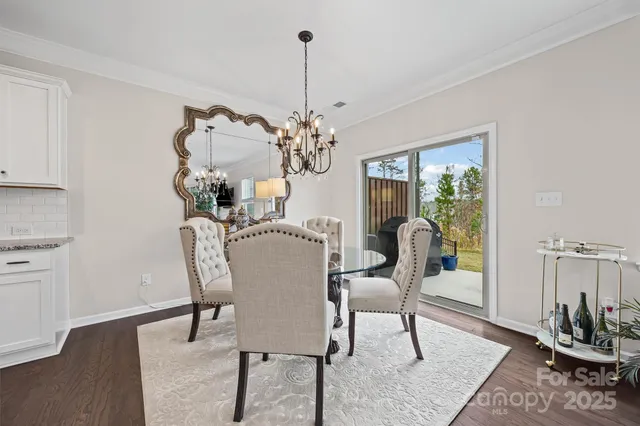 a dining room with furniture potted plants and wooden floor