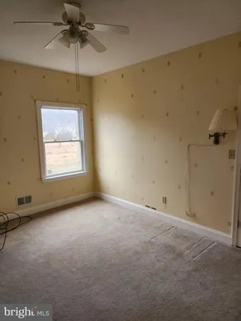 an empty room with a window and a ceiling fan