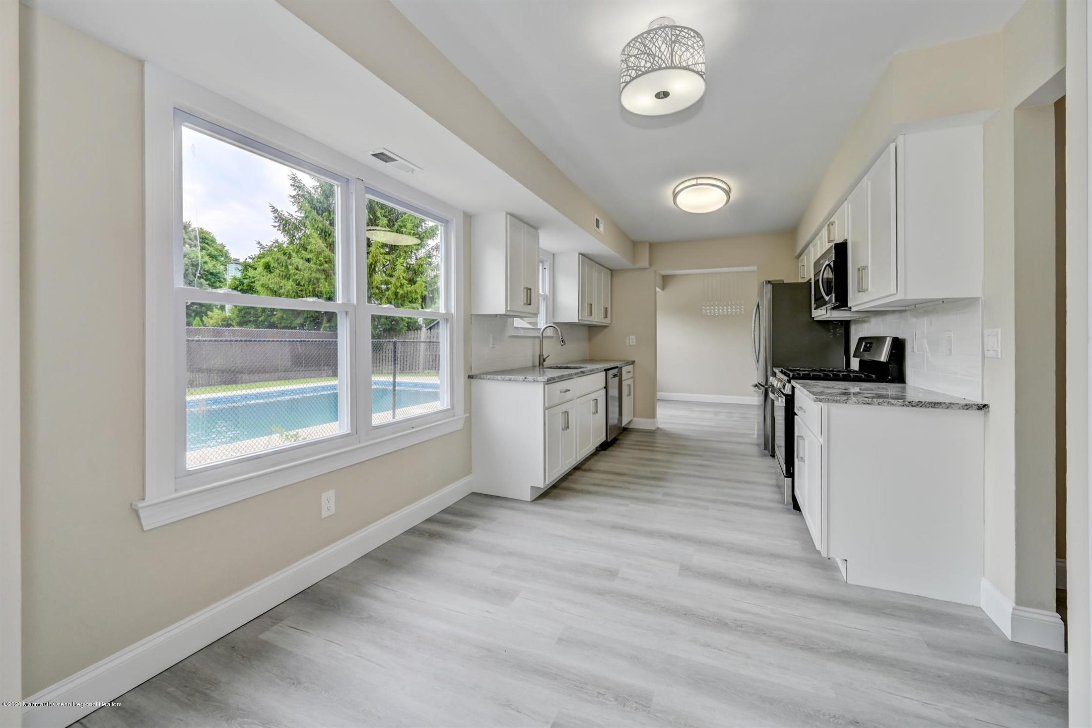11 Rita Drive Howell, NJ 07731 - Photo 6 of 26 a kitchen with stainless steel appliances a stove top oven a sink a refrigerator cabinets and a large window