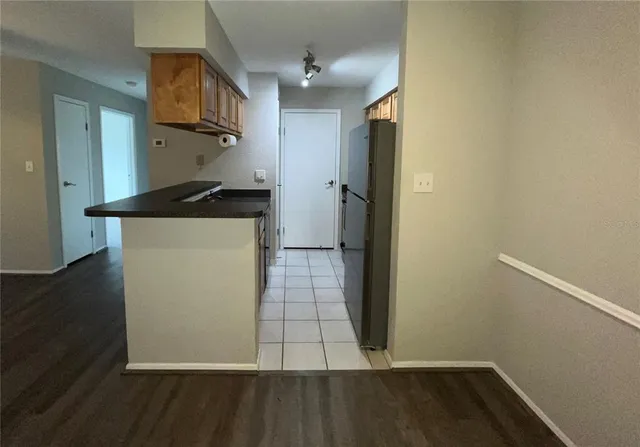 a kitchen with metallic refrigerator and a stove top oven