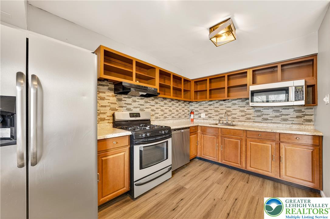 1575 Creekside Road, Unit A2 Whitehall, PA 18052 - Photo 12 of 26 a kitchen with stainless steel appliances granite countertop a stove and a refrigerator