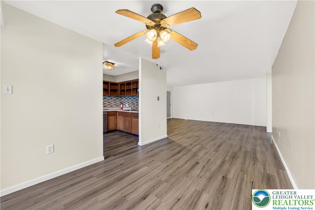1575 Creekside Road, Unit A2 Whitehall, PA 18052 - Photo 10 of 26 a view of a livingroom with wooden floor a ceiling fan and window