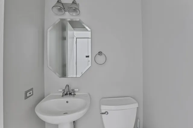 a bathroom with a toilet a sink and mirror