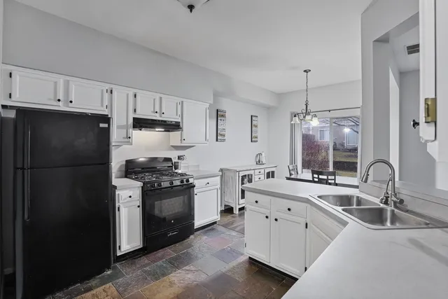 a kitchen with white cabinets and appliances