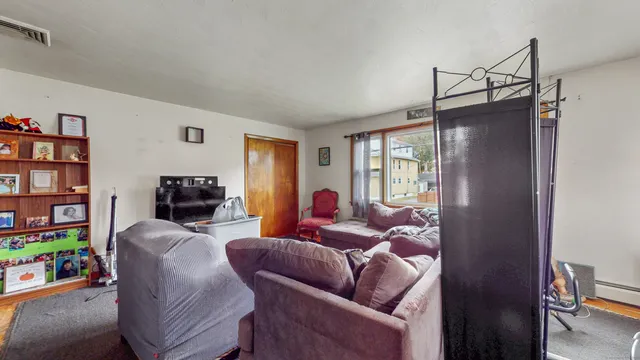 a living room with furniture a window and a flat screen tv