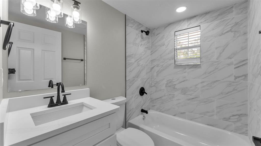 2211 Azalea Court Lakeland, FL 33815 - Photo 14 of 22 a bathroom with a sink a toilet a bathtub and shower