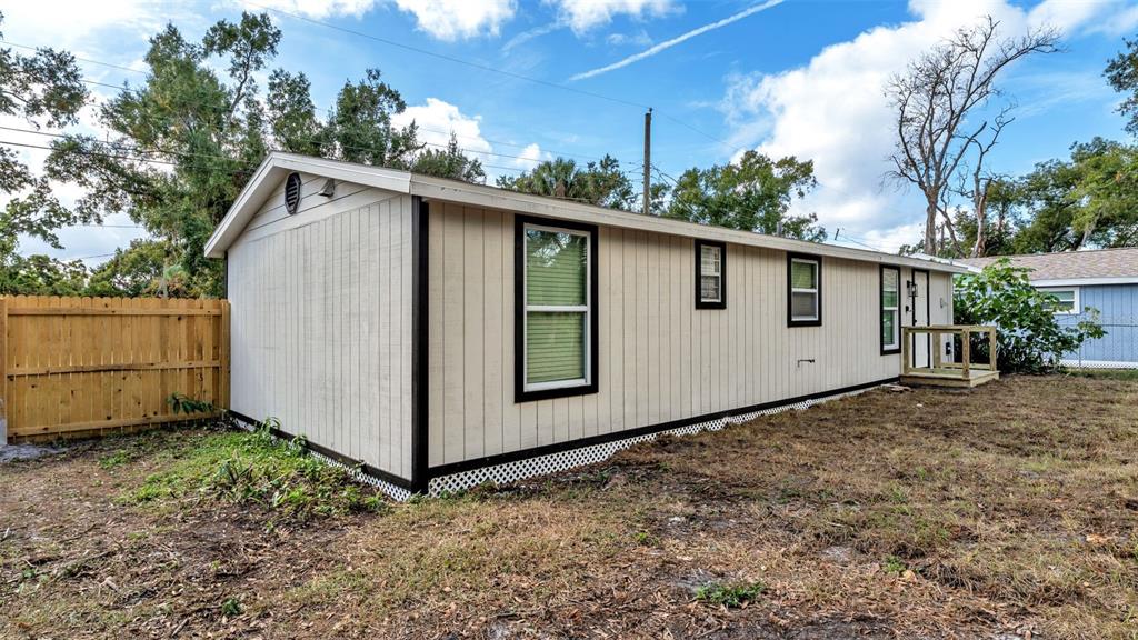 2211 Azalea Court Lakeland, FL 33815 - Photo 21 of 22 a view of a small white house with a large window and garage
