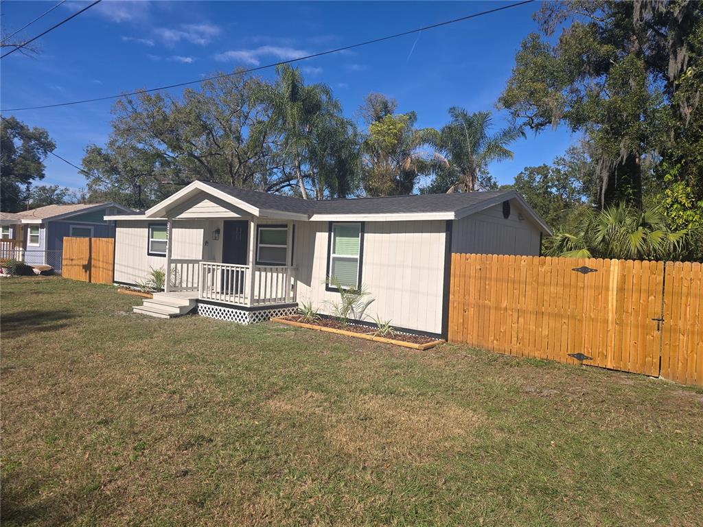 2211 Azalea Court Lakeland, FL 33815 - Photo 6 of 22 a white house with a small yard and large trees