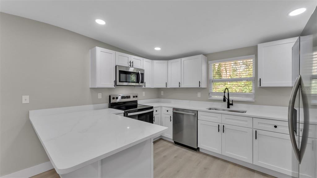2211 Azalea Court Lakeland, FL 33815 - Photo 7 of 22 a kitchen with a sink a window and stainless steel appliances