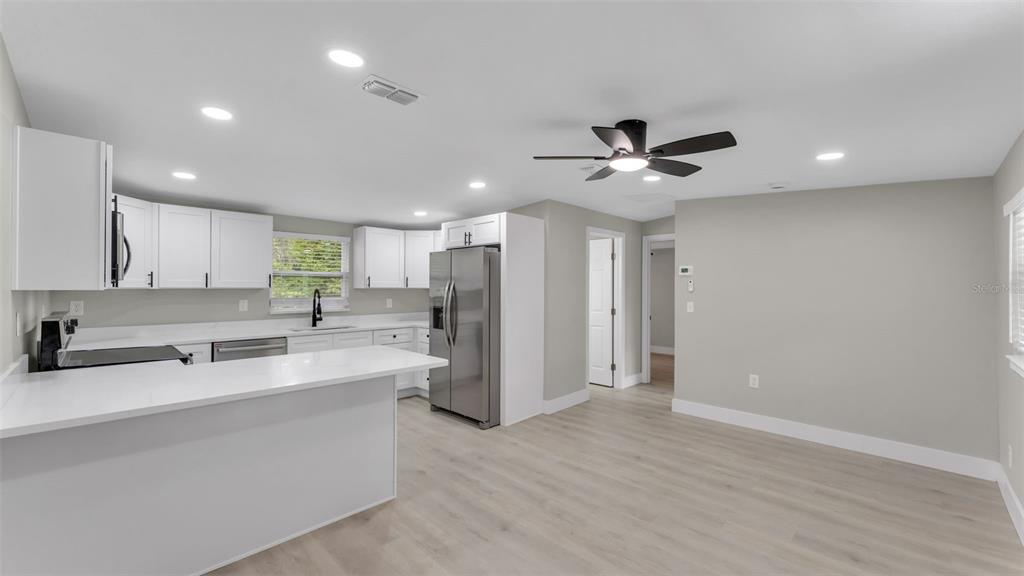 2211 Azalea Court Lakeland, FL 33815 - Photo 8 of 22 a large white kitchen with a sink stainless steel appliances and cabinets