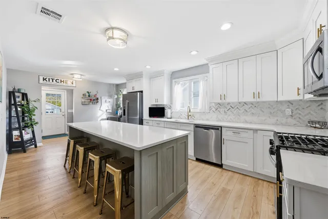 a kitchen with kitchen island a sink table and chairs