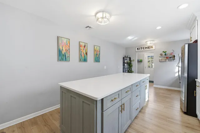 a kitchen with cabinets and wooden floor