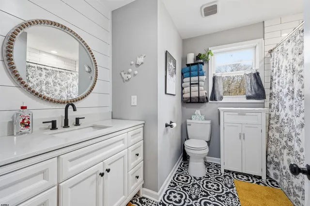 a bathroom with a sink a toilet and a mirror