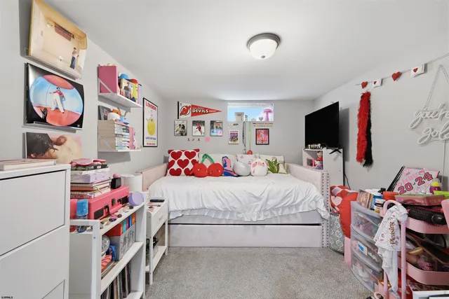 a bedroom with a bed a dresser and a flat screen tv