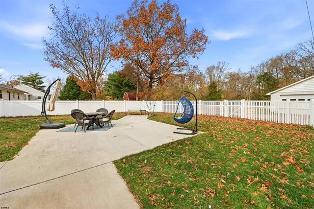 a view of backyard with table and chairs and wooden fence