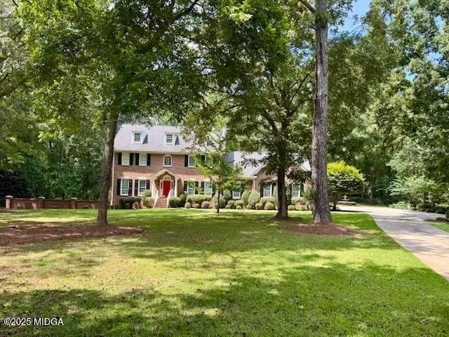 a view of a house with a big yard and large trees