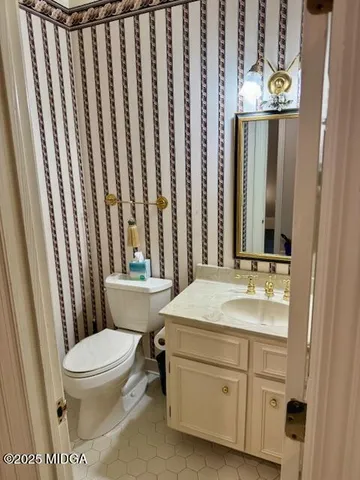 a bathroom with a granite countertop sink toilet and mirror