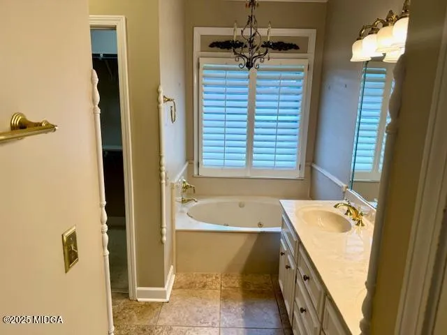 a bathroom with a tub a sink and a mirror