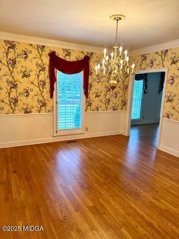 a view of a chandelier in hallway with chandelier and wooden floor