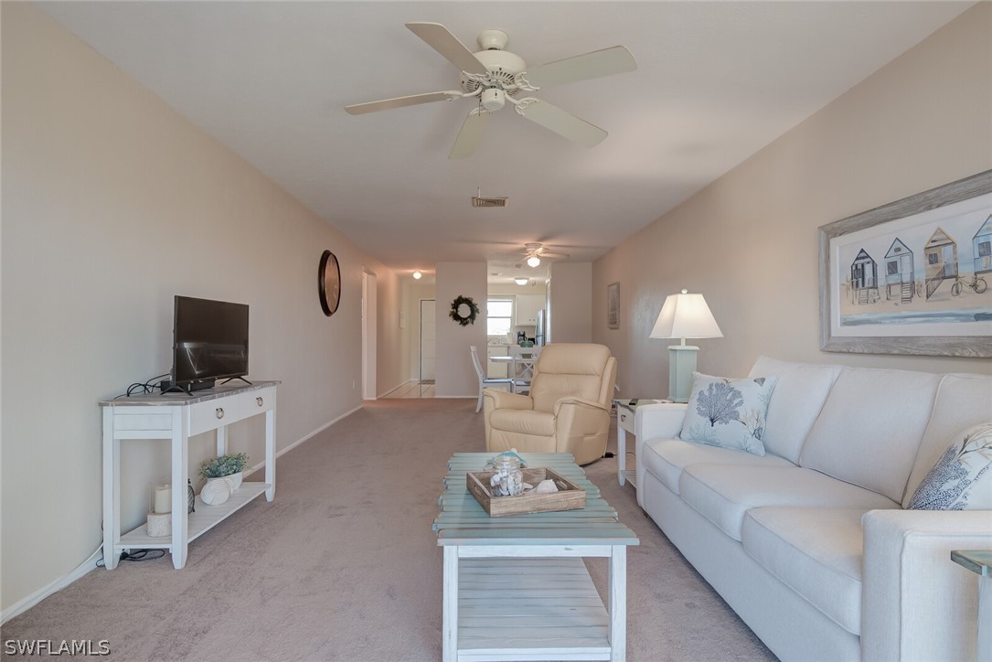6777 Winkler Road, Unit 237 Fort Myers, FL 33919 - Photo 4 of 23 a living room with furniture a rug and a chandelier