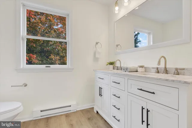 a bathroom with a granite countertop sink mirror and toilet
