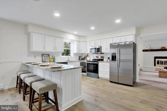 a kitchen with kitchen island a refrigerator stove microwave and cabinets