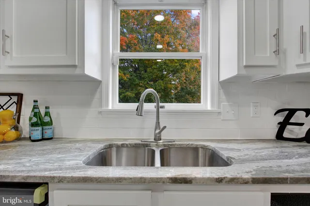 a kitchen sink with a granite countertop window