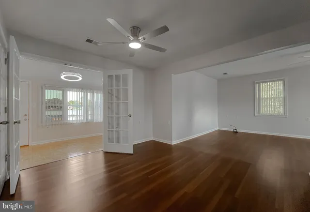 a view of an empty room with a chandelier fan