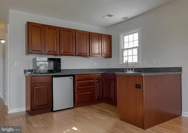 an empty room with a chandelier fan and view of bathroom